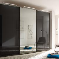 Schwarze Hochglanzflächen mit Spiegel und LED-Beleuchtung am Kleiderschrank